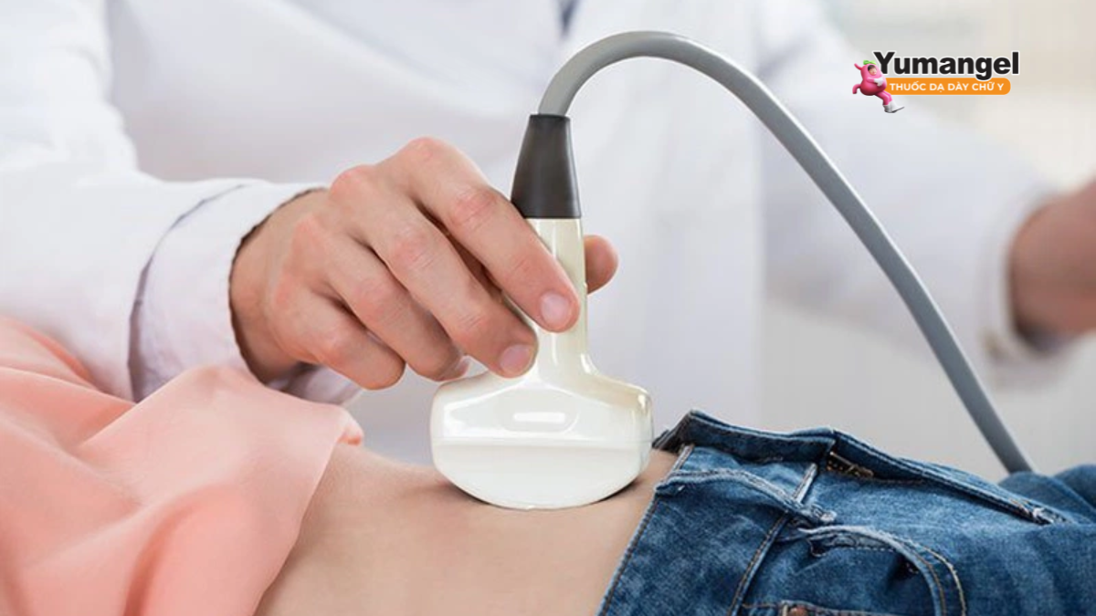 Người bệnh nằm ngửa trên giường khám, kéo áo để lộ vùng bụng